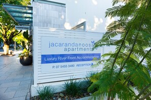 A sign for Jacaranda Apartments, indicating Luxury River Front Accommodation with a reception and contact number. - Jacaranda 12 Hastings Street 12 (Noosa Heads)