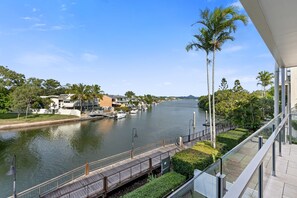 Een rivierzicht met een brug, boten en gebouwen langs het water.