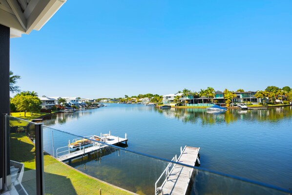 A waterfront property with a dock, boats, and a clear view of the water.