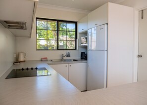 A modern kitchen with a built-in stove, a sink, and a refrigerator.