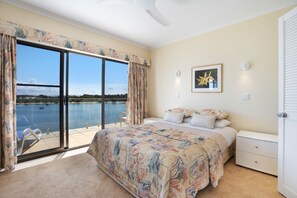 Une chambre avec un grand lit, une vue sur la mer et un balcon.