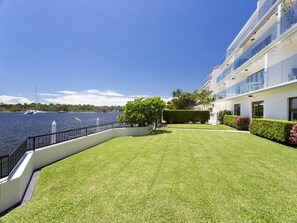 A modern building with a glass facade overlooking a body of water.