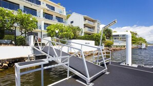 A marina with a dock, a waterway, and a building with balconies. - Aqua Linea 3 Noosa Parade 82 (Noosa Heads)