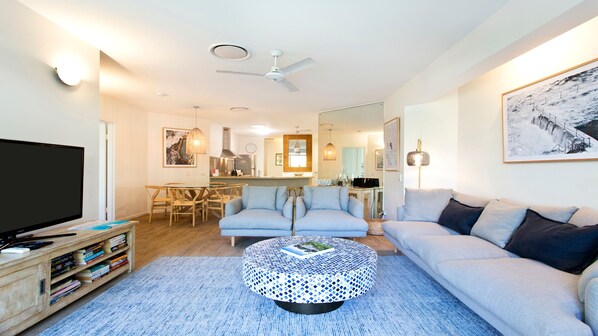 A modern living room with a sofa, coffee table, and a TV.