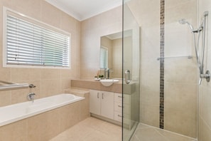 Une salle de bain moderne dotée d’une douche à parois de verre, d’une baignoire et d’un meuble-lavabo.