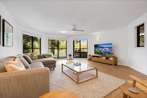 A modern living room with a sofa, coffee table, and television.