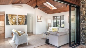Relax in a spacious living area with a sofa, side table, and wicker chair.