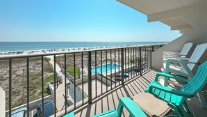 Un balcon avec vue sur la plage et une zone avec piscine.