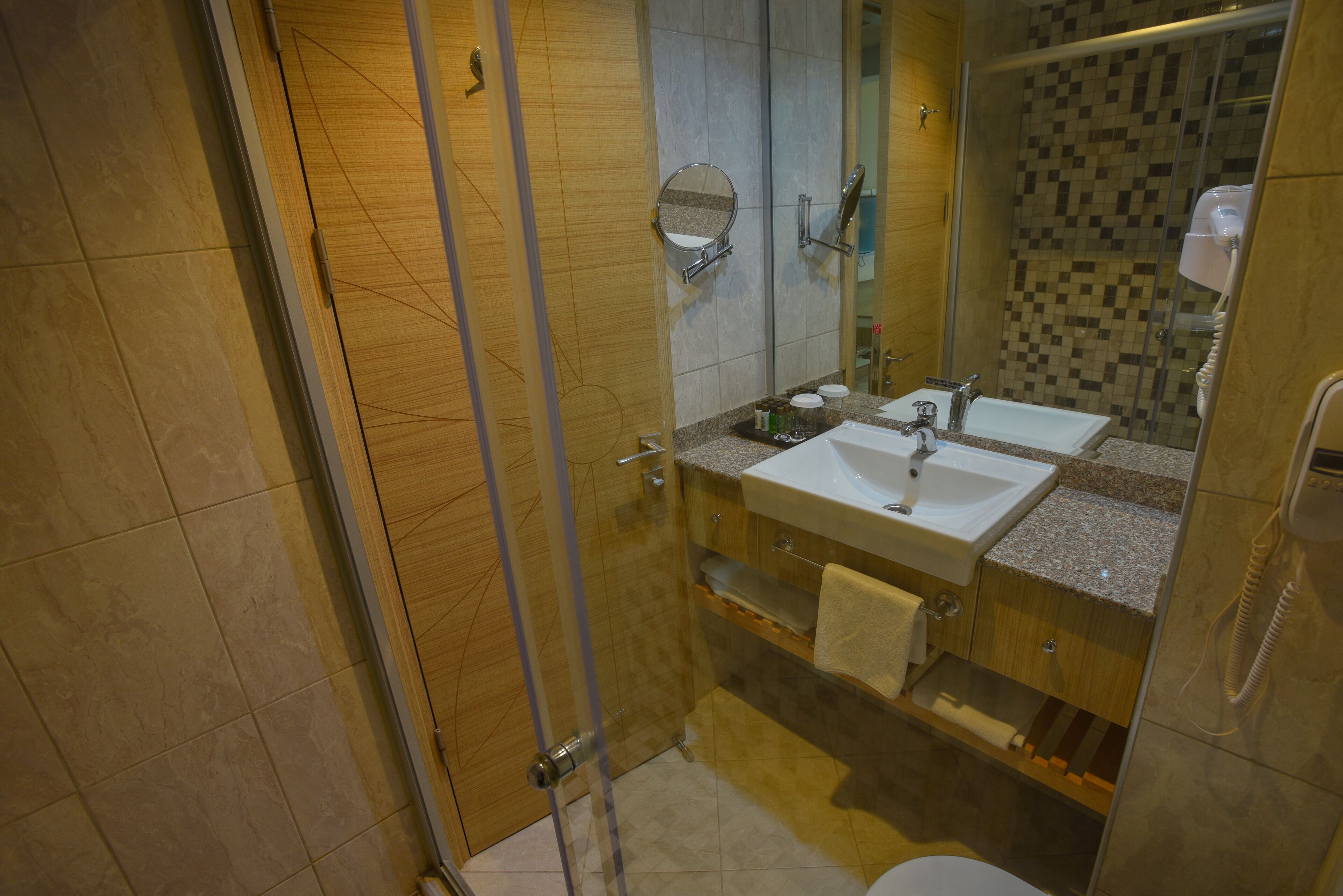 Une salle de bain moderne avec deux lavabos, une cabine de douche en verre et un mur de douche recouvert de carreaux.