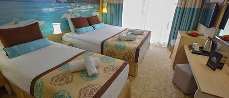 A hotel room with two beds, a desk, and a large window with curtains.