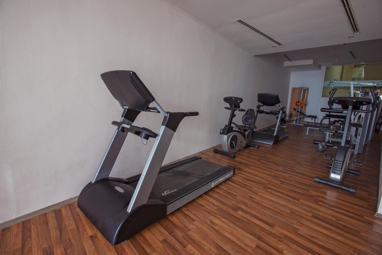 A gym with treadmills, stationary bikes, and weight machines.