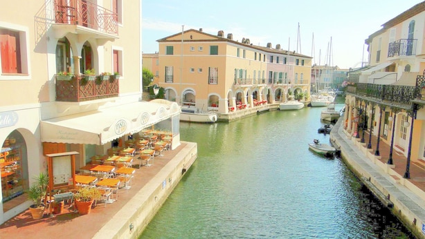 A canal-side restaurant with outdoor seating and a view of the water.