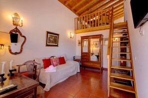 A room with a bed, a wooden ladder, a TV, and a wooden cabinet.