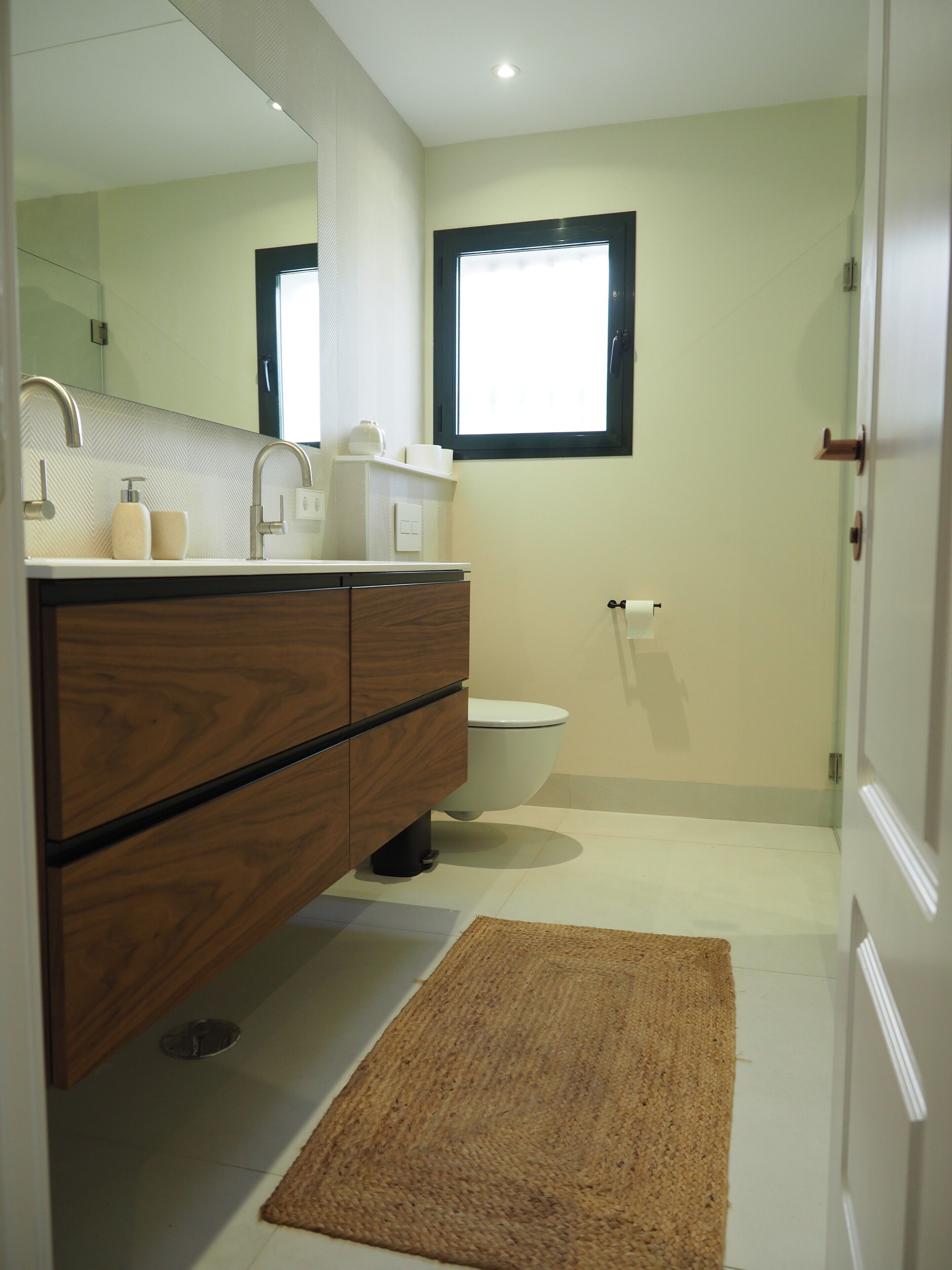 Une salle de bain moderne avec un meuble-lavabo en bois, des toilettes, une douche et un grand miroir.