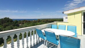 A balcony with a white balustrade, a round table, and blue chairs. - Apartment 56/34816 (Istria - Stinjan), 1000m from the beach (Stinjan)