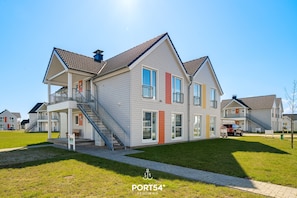 A modern two-story house with a covered porch, a staircase, and a garage.