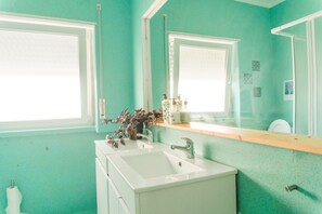 Ein Badezimmer mit zwei Waschbecken, einem Spiegel und einem Fenster.