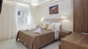 Une chambre d’hôtel avec un lit, des tables de chevet, un tableau au mur et une fenêtre avec des rideaux.