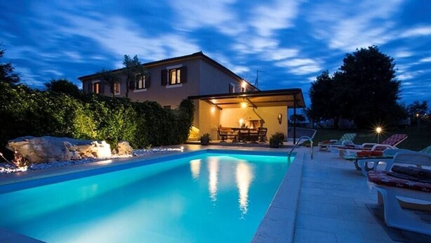 A swimming pool with lounge chairs and a house in the background. - Vacation home with pool - a paradise for families (Žminj)