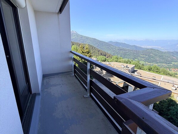 A balcony with a view of a mountainous landscape.