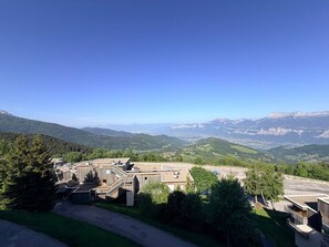 A building with a flat roof, a staircase, and a view of a valley and mountains.