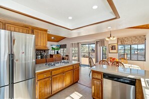 Une cuisine moderne avec des meubles en bois, des appareils électroménagers en acier inoxydable et un grand ßlot central.