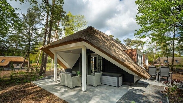 A modern house with a sloped roof and a covered patio area. - Sprielderbosch 10 quietly located in a luxury park near Garderen (Putten)