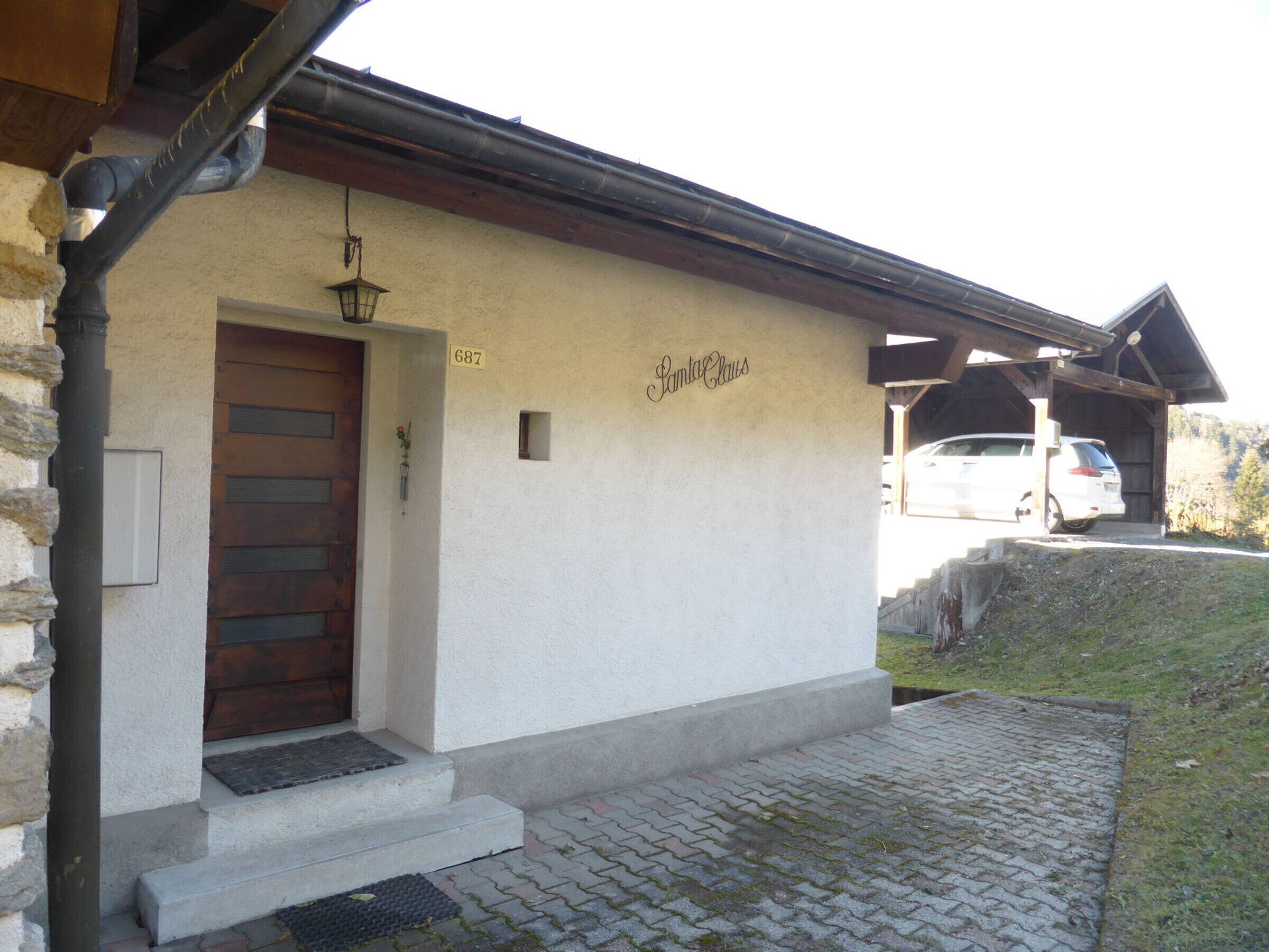 A building with a wooden door, a small window, and a sign reading "Santa Claus".