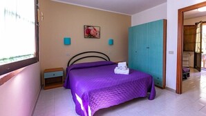 A bedroom with a bed, a wardrobe, a nightstand, and a painting on the wall.