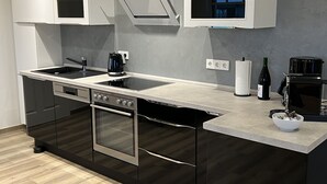 Una cocina moderna con una isla central, horno empotrado y electrodomésticos de acero inoxidable.