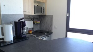 Eine moderne Küche mit Kaffeemaschine, Wasserkocher und Mikrowelle.