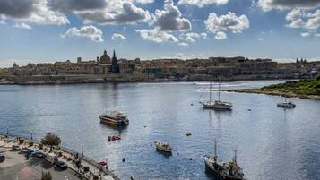 A harbor with boats, a cityscape in the background, and a clear sky.