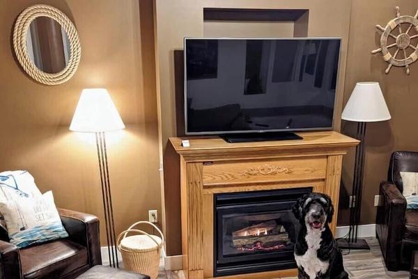 Snuggle up by the glowing fireplace in this inviting living space.