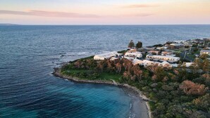 Luchtbeeld van een kustgebied met woningen en een strand.