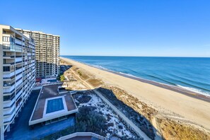 Un hôtel de grande hauteur doté de nombreux balcons donnant sur une plage.