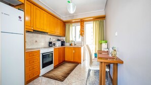 Una cocina con armarios de madera, un refrigerador Bosch, una estufa y un comedor con mesa y sillas.