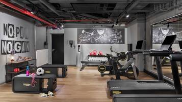 A gym with exercise equipment, motivational wall art, and a shoe rack.