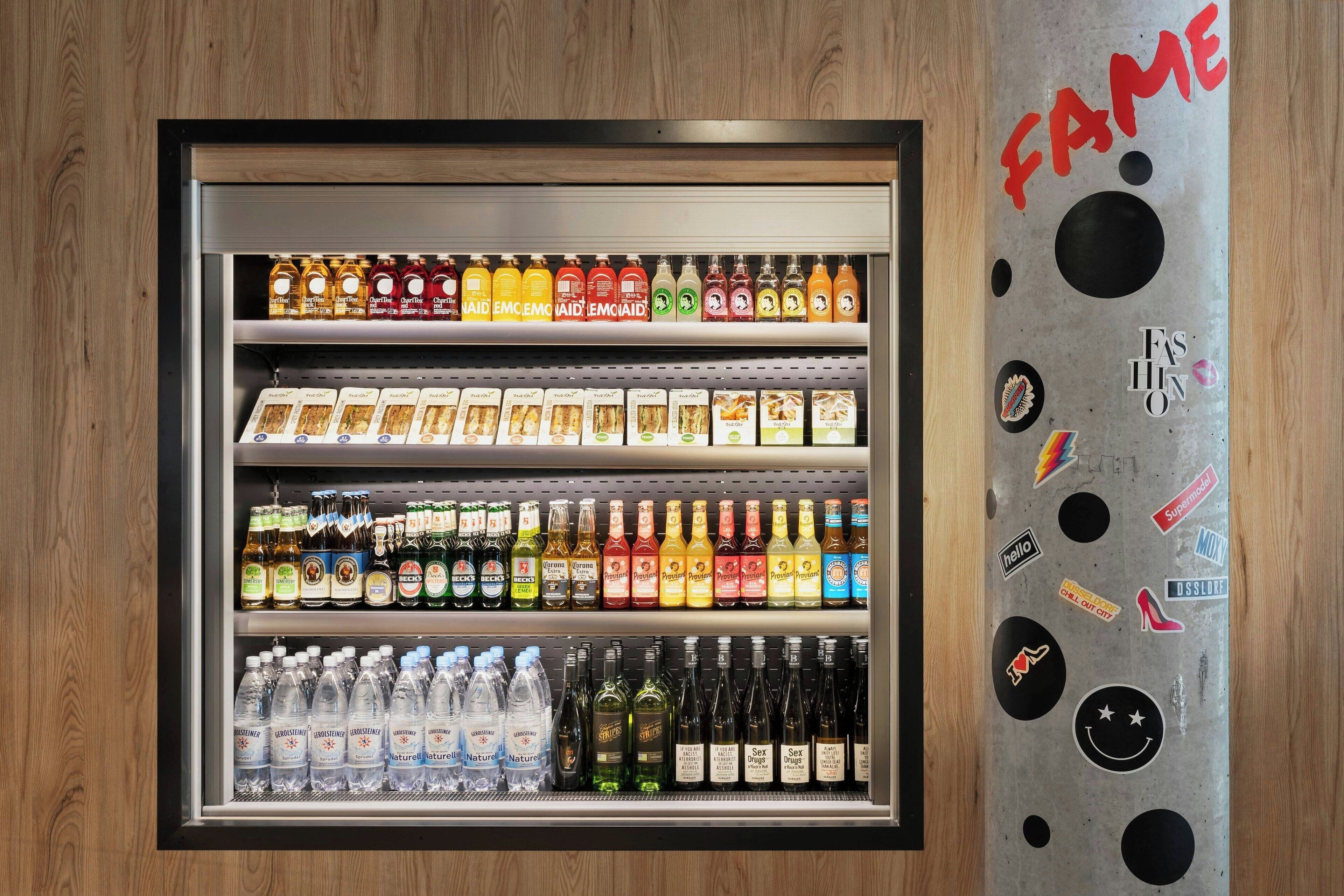 Máquina expendedora de bebidas con varios estantes llenos de distintas opciones.