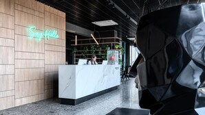 A modern reception area with a neon 'Say Hello' sign, a marble reception desk, and a black geometric sculpture. - WOL 121 (Odesa)