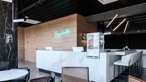 A modern bar area with a neon sign, wooden paneling, and seating arrangements. - WOL 121 (Odesa)