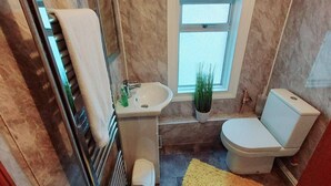 A bathroom with a white sink, a toilet, and a window. - Garfield Villa-beautiful 4-bed House in Gillingham (Gillingham)