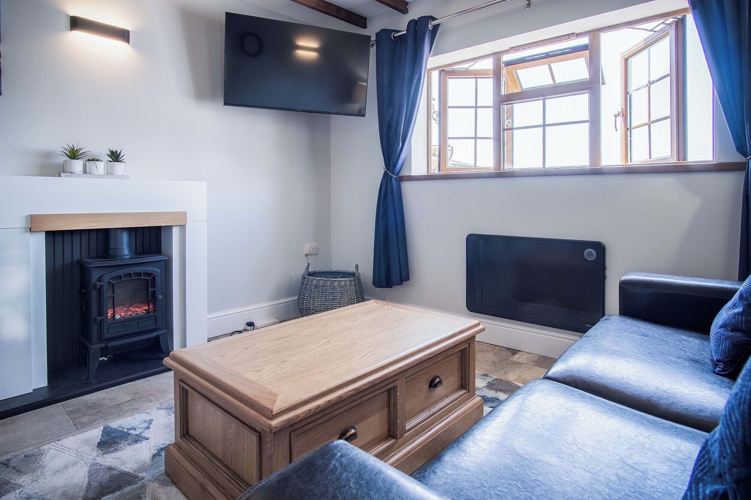 A living room with a fireplace, sofa, and television.
