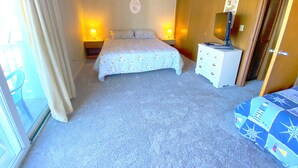 A bedroom with a bed, bedside tables, a dresser, and a mirror.