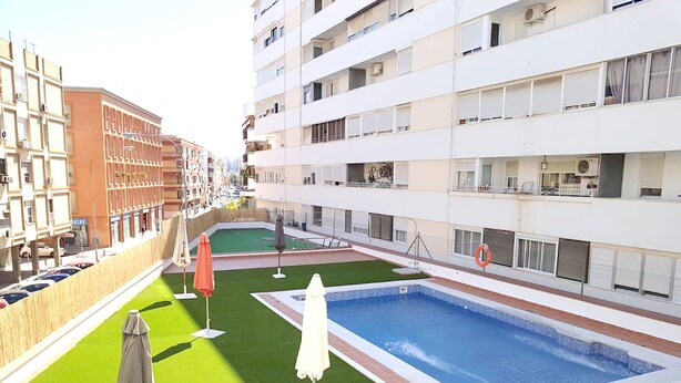 A rooftop pool area with a swimming pool, green artificial turf, and umbrellas. - Centrally located apartment in Triana, Seville+swimming pool (Sevilla)