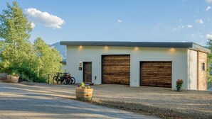 A single-story building with two large garage doors, a small entrance, and a bicycle parked outside.