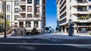 Eine moderne Stadtstraße mit Hochhäusern, blauem Himmel und einer Fußgängerampel.