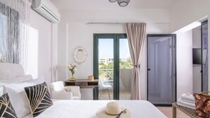 Ett hotellrum med en säng, ett skrivbord, en stol, en balkong med utsikt och en luftkonditioneringsanläggning.