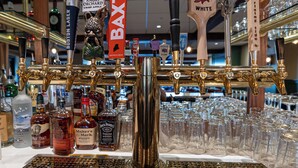Un bar con múltiples grifos de cerveza y una variedad de botellas de licor.