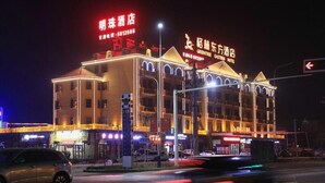 A multi-story hotel with illuminated signage, a prominent entrance, and a parking area. - Greentree Eastern Xinjiang Aksu Airport Hotel (Wensu County)