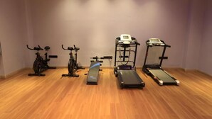 A room with four exercise machines: two stationary bikes, a treadmill, and a stair climber. - Greentree Eastern Xinjiang Aksu Airport Hotel (Wensu County)
